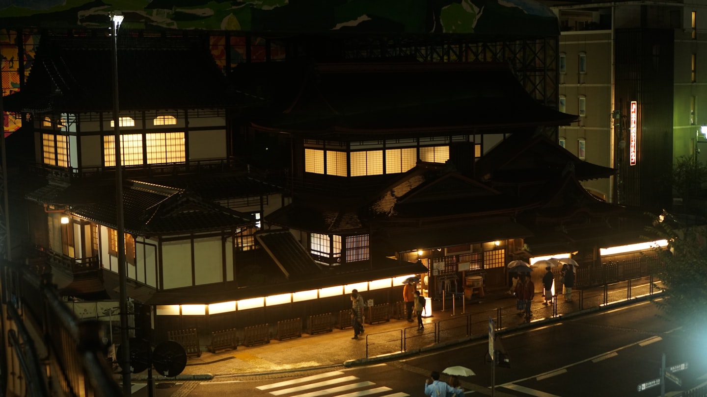 A warm lantern-lit Japanese accommodation entrance at night