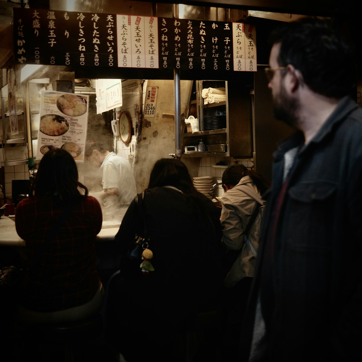 Guests eating at a busy Japanese restaurant counter