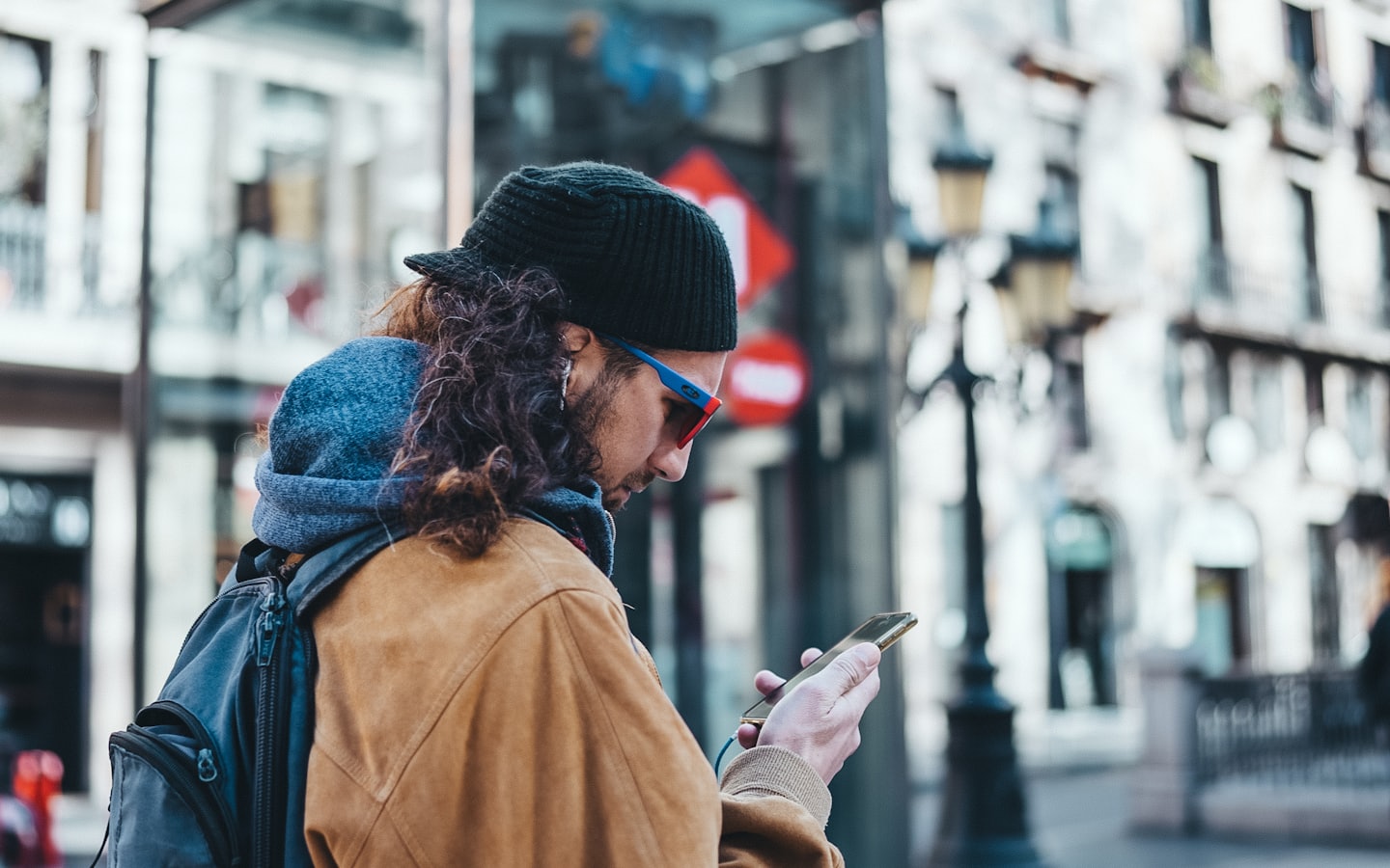 A traveller checking their smartphone on a city street