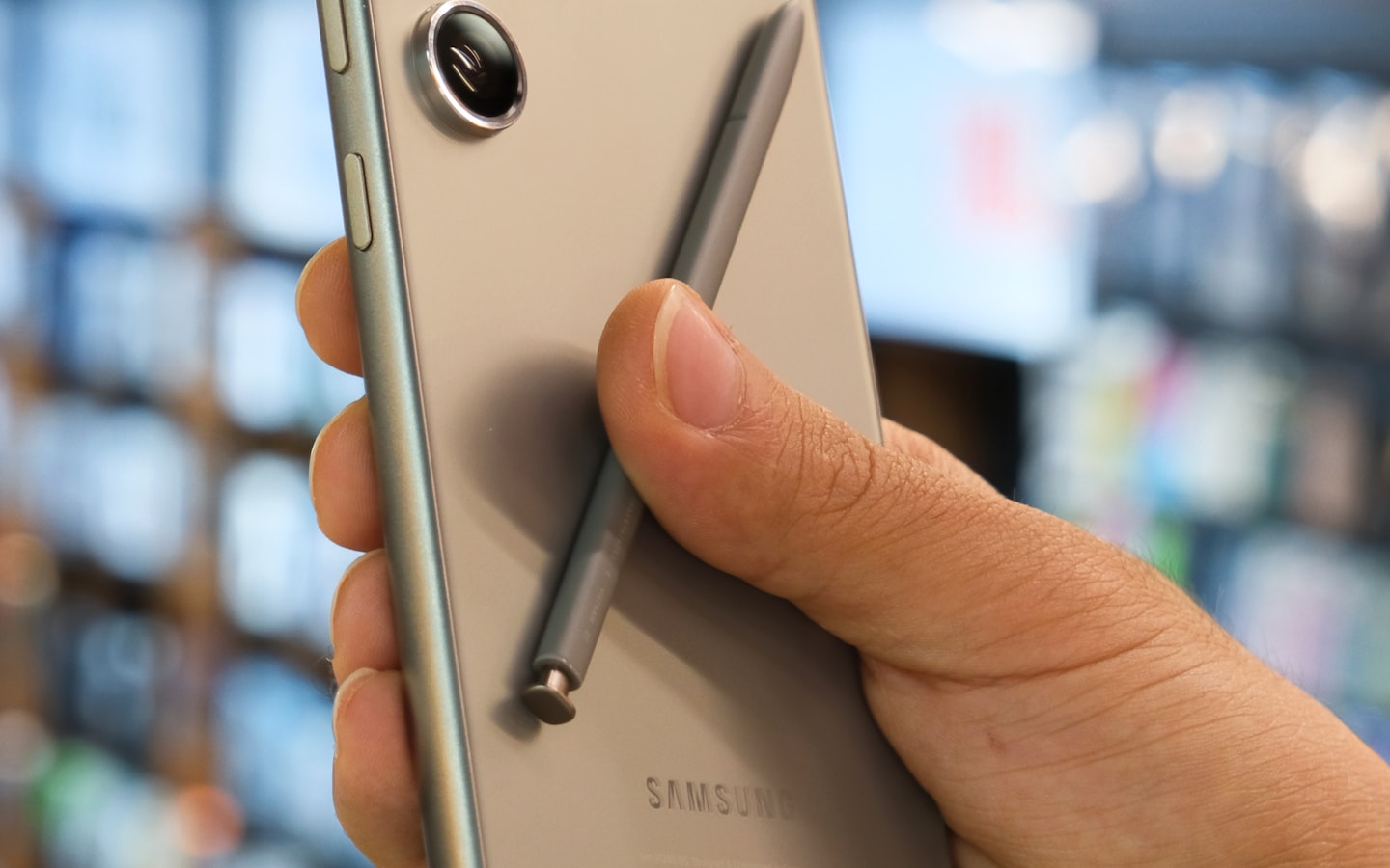 A hand holding a Samsung Galaxy phone with its S Pen
